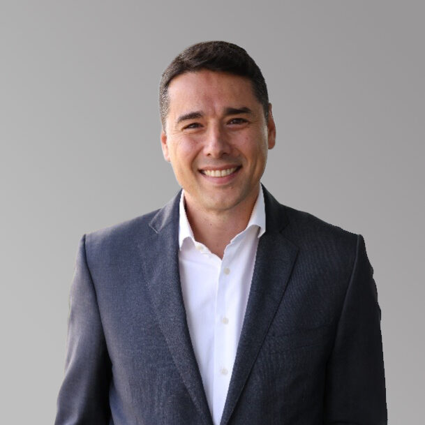 Jacinto Monge has dark hair and a wide smile. He is professionally dressed in a gray suit jacket with a crisp white shirt.